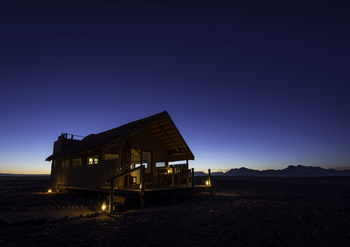Kulala Desert Lodge: Gästezelt von außen am Abend