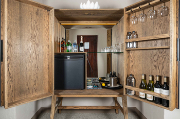 Sabi Sabi Bush Lodge: Eleganter Holz-Minibar mit Getränken und Gläsern