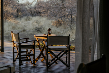 Otjiwa Thornbush Tented Camp: Safari-Regiestühle und Laterne im goldenen Morgenlicht