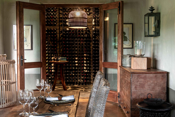 Singita Castleton: Esszimmer mit Holztisch und gläsernem Weinkeller