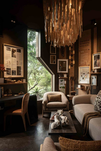 Singita Lebombo Lodge: Lounge mit Sessel, Sofa und Fossilien-Tisch