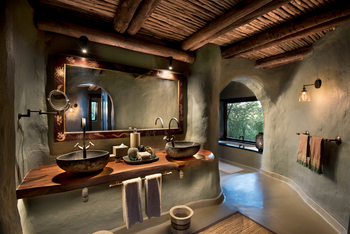 andBeyond Phinda Rock Lodge: Doppelwaschtisch, Steinwaschbecken und kunstvoller Spiegelrahmen
