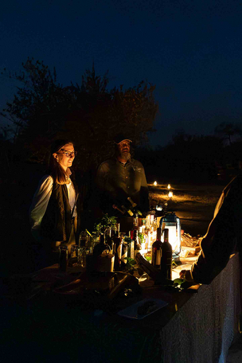 Notten's Bush Camp: Zwei Gäste an beleuchteter Buschbar mit Spirituosen