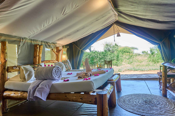 Ikoma Tented Camp: Bett mit Handtüchern und Blütenblättern