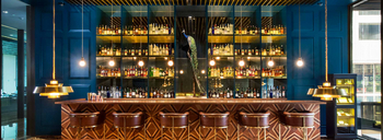 Roseate House: Luxuriöse Bar mit Pfau und goldener Beleuchtung