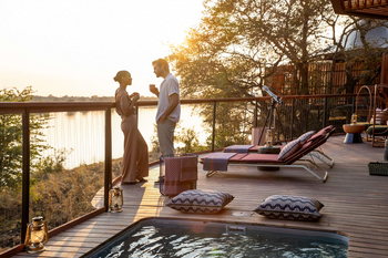 Anantara Tented Camp Kafue River: Paar beim goldenen Sundowner auf Flussdeck