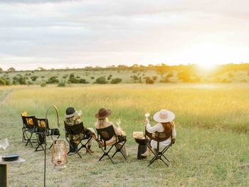 Cheetah Plains: Vier Gäste beim Sundowner über weite Savanne