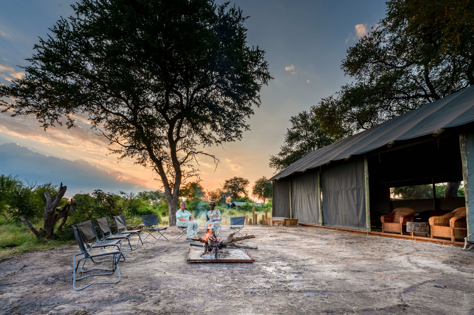 Losika Elephant Camp Losika Elephant Camp: Gäste am Lagerfeuer im goldenen Abendlicht
