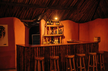 Migunga Tented Camp: Rustikale Bar mit Holztheke und Beleuchtung