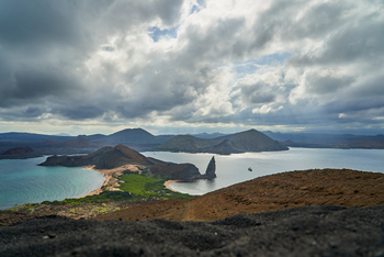 andBeyond Galapagos Explorer: Vulkanisches Panorama mit Felsnadel und türkisen Buchten