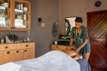 Madikwe Hills Private Game Lodge: Spa-Raum mit Massagetisch und Holzschrank