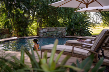 Savanna Lodge: Poolterrasse mit Liegen unter weißer Nachmittagssonne