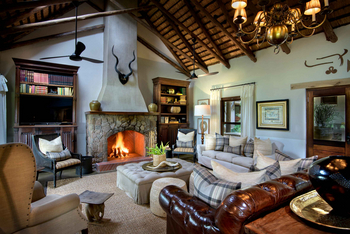 Singita Castleton: Wohnlounge mit brennendem Steinkamin und Antilopenkopf