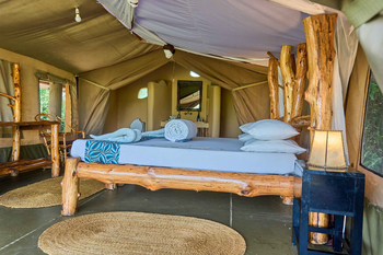 Ikoma Tented Camp: Großes Holzgestellbett mit dekorativem Läufer