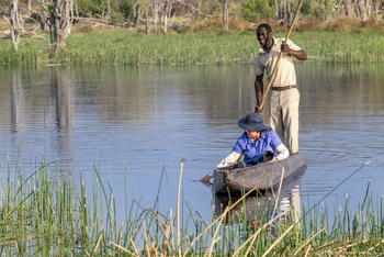 Losika Elephant Camp: Gast greift ins Wasser vom Mokoro