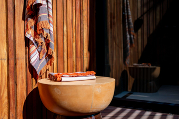 Anantara Tented Camp Kafue River: Runder Steintisch mit gestreiftem Plaid im Sonnenlicht