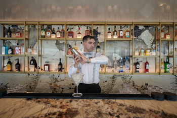 Scenic Eclipse II: Barkeeper schüttelt Cocktail vor luxuriöser Marmorwand