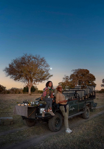 Singita Castleton: Paar beim Sundowner am Safarifahrzeug