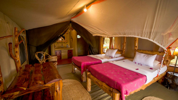Ikoma Tented Camp: Rustikale Betten mit rosafarbigen Akzenten