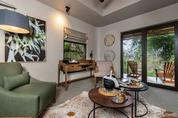 Sabi Sabi Bush Lodge: Gepolsterter Sessel neben Holzschreibtisch und Trennwand