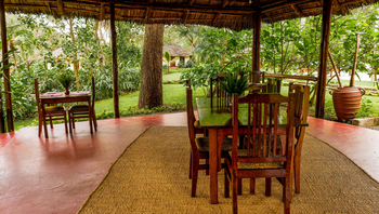 Arusha Safari Lodge: Outdoor Essbereich mit Holz-Tischen und Teppich