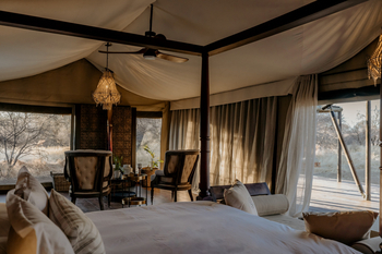 Otjiwa Thornbush Tented Camp: Luxus-Schlafzimmer mit Kristallkronleuchtern und Polstersesseln