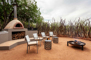 Little Madikwe Hills: Offener Lounge-Bereich mit Feuerstelle und Ofen