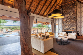 Little Madikwe Hills: Lounge mit Sofa und Naturstein-Kamin