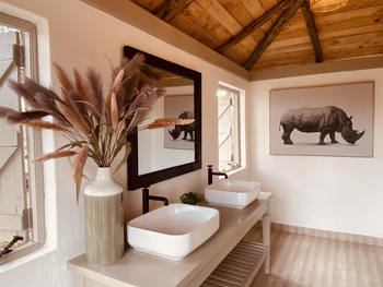 The River Camp: Badezimmer mit Doppelwaschbecken und Holzspiegel