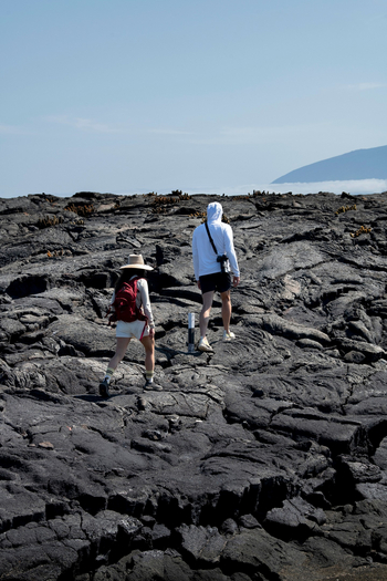 andBeyond Galapagos Explorer: Trekkende Gäste auf schroffem Vulkangestein