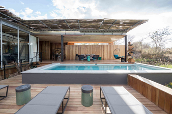 Singita Sweni Lodge: Zwei graue Sonnenliegen auf Busch-Holzdeck