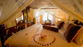 Arusha Safari Lodge: Romantisches Bett mit Moskitonetz und Blütenherz