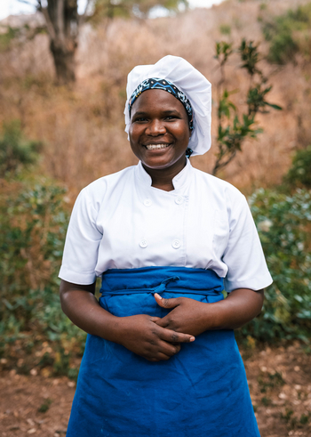 Mkomazi Wilderness Retreat: Strahlende Küchenchefin mit bunter Kopfbedeckung