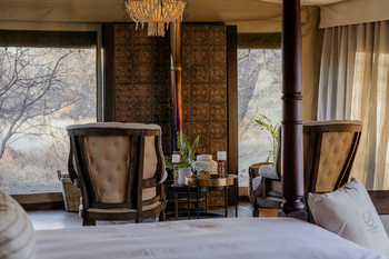 Otjiwa Thornbush Tented Camp: Elegante Canvas-Lounge mit zwei Armlehnsesseln und Goldtisch