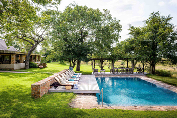 Singita Castleton: Pooldeck mit gepolsterten Safariliegen und Pergola