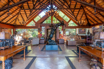 Mateya Safari Lodge: Lounge mit Holztischen und Tierstatue