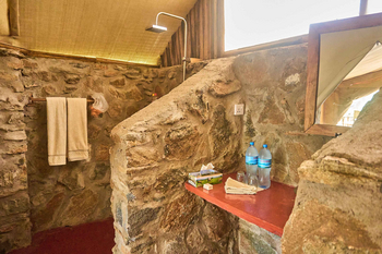 Tindiga Tented Camp: Rustikale Steinwand-Dusche mit Handtüchern