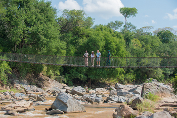 Mkulumadzi Lodge: Guide mit Gästen auf der Brücke