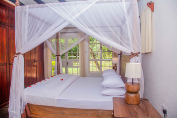 Moivaro Lodge: Schlafzimmer mit Moskitonetz und Blütenblättern