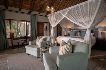 Savanna Lodge: Kingsizebett unter zartem Baldachin mit Weingläsern