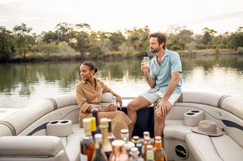 Anantara Tented Camp Kafue River: Zwei Gäste bei Sundowner auf Flussboot