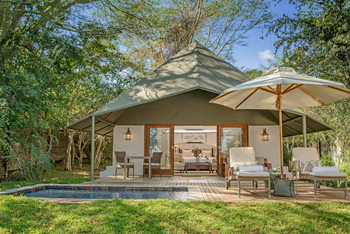 Savanna Lodge: Holzdeck mit Polsterliegen und Weinkühler unter Schirm