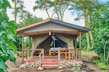 Migunga Tented Camp: Essbereich mit Holzmöbeln im Grünen