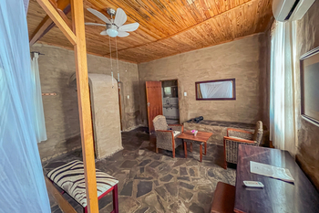 Fort Sesfontein Lodge: Gemütlicher Loungebereich mit Korbsessel und Zebrabank