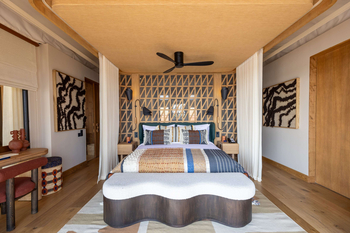 Anantara Tented Camp Kafue River: Schlafzimmer mit Bettüberwurf und Flechtbank