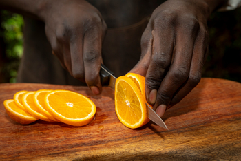 Shebas Secret Garden: Mitarbeiter schneidet eine Orange