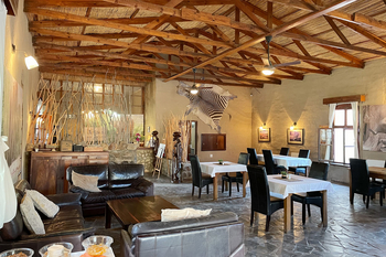 Fort Sesfontein Lodge: Lounge mit Zebrafell und rustikalen Ledersofas