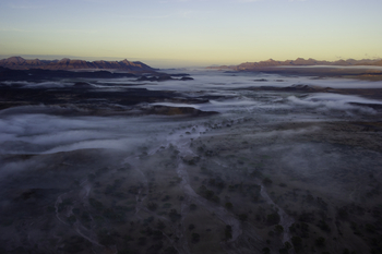 Damaraland Camp: Luftaufnahme des nebelverhangenen Hoab-Flusses