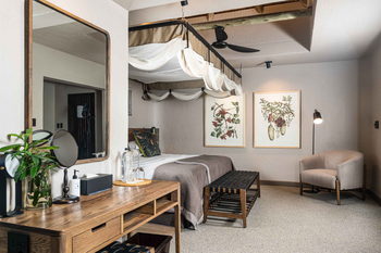 Sabi Sabi Bush Lodge: Schlafzimmer mit Holz-Baldachinbett und Pflanzenmuster