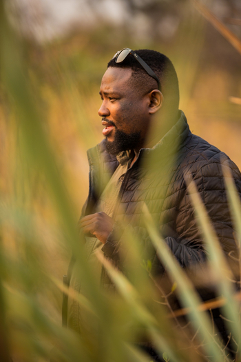 Sitatunga Private Island Camp: Mann hinter Busch